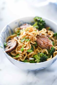 a bowl filled with noodles, broccoli and meat