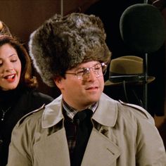 a man wearing a fur hat next to a woman