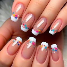 The nails have a clear or nude base with French tips in white. Over the white tips, tiny rainbow-colored polka dots are evenly placed, creating a playful and colorful twist on the classic French manicure. The dots are vibrant and stand out against the white tips. A glossy top coat adds a smooth, finished look. French Dots Nails, Rainbow Glitter French Tip Nails, Tipped Nail Designs, Funky French Manicure, Clear Nails With Polka Dots, Colored French Dip Nails, French Manicure With Nail Art, Girly French Tip Nails, Colour French Manicure