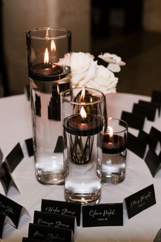 candles and place cards on a table with flowers