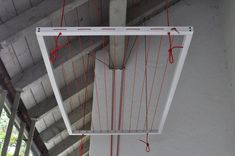 a white box hanging from the ceiling with red wires attached to it's sides