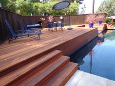 a wooden deck next to a swimming pool