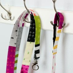 three lanyards hanging from hooks on a wall