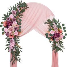 an arch decorated with pink flowers and greenery