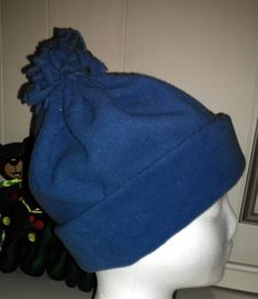 a blue hat sitting on top of a mannequin's head in front of a mirror