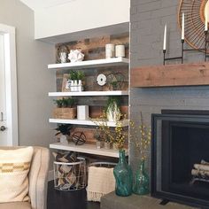 a living room filled with furniture and a fire place in front of a brick wall