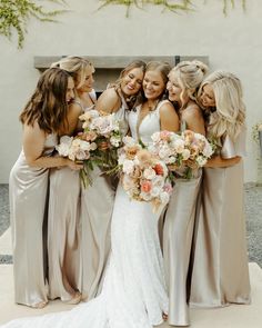 a group of women standing next to each other in front of a building with flowers