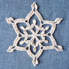 a crocheted snowflake on blue fabric