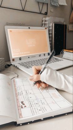 a person is sitting at a desk with a notebook and pen in front of them