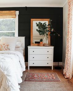 a bedroom with black walls and white furniture