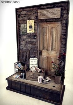 a display case with books and other items in it on a table next to a brick wall