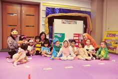 a group of children sitting on the floor in front of a whiteboard