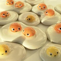 eggs with faces drawn on them sitting in an egg shell, surrounded by smaller ones