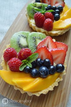 fruit tarts with kiwis, raspberries and blueberries on top