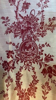 a red and white wallpaper with floral designs on the bottom half of it,