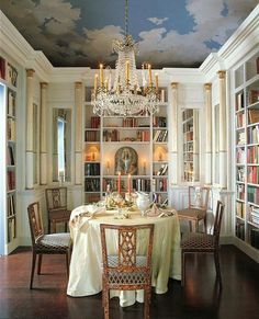 a dining room with a table, chairs and chandelier in it's center