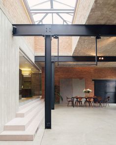 an indoor dining area with stairs leading up to the second floor and skylights above