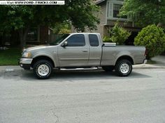 a silver pick up truck parked in front of a house