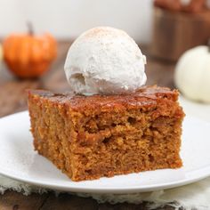 a piece of cake on a white plate with a scoop of ice cream on top