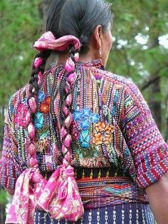 a woman with braids in her hair wearing a colorful dress and carrying a purse