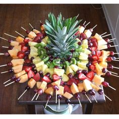 a pineapple surrounded by fruits and skewers