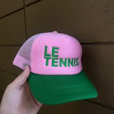 Le Tennis. Pink And Green- The Perfect Combo! Serve In Style With This New Hat. The Nylon And Mesh Trucker Hat Is The Perfect Unisex Accessory Snap-Back Closure One Size Fits Most Pink Cap For Summer, Pink Baseball Cap For Summer Sports, Pink Summer Sports Baseball Cap, Pink Sports Hats For Summer, Pink Cap Mini Hat For Summer, Playful Pink Mini Hat For Summer, Pink Adjustable Baseball Cap For Summer, Pink Baseball Cap For Sports In Spring, Pink Baseball Cap For Spring Sports