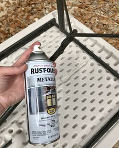 a person is holding a spray can of rustoleum on a grate in the kitchen