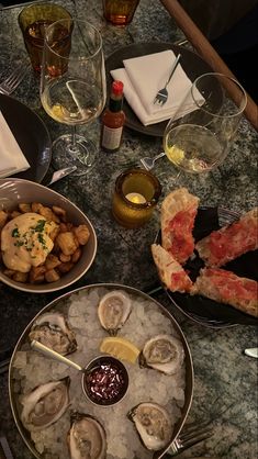 an assortment of oysters and wine on a table