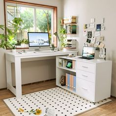 a desk with a computer on top of it next to a potted plant in front of a window