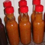 four bottles filled with hot sauce sitting on top of a counter