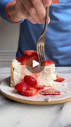 a person is eating a piece of cake with strawberries on it and holding a fork