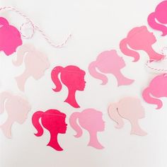 pink and white paper cut outs with silhouettes of women's heads on them