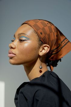 a woman with blue eyeshades and a head scarf on top of her head