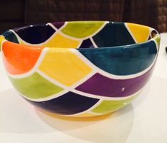 a colorful bowl sitting on top of a white table