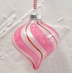 a pink and white ornament hanging on a wall