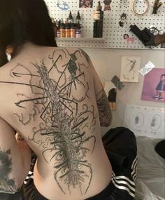 the back of a woman's body with tattoos on it