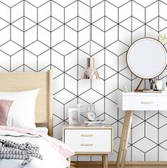 a bedroom with white and black geometric wallpaper next to a bed, nightstands and mirror