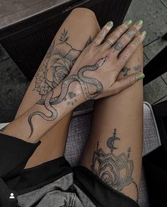 a woman's legs with tattoos on them and her hands resting on the ground