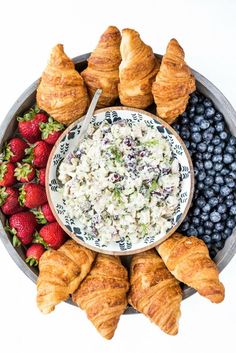 croissants, blueberries, strawberries and cream cheese on a platter