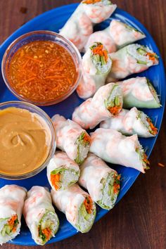 a blue plate topped with sushi and dipping sauce