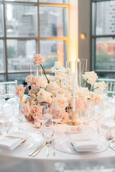 the table is set with white and pink flowers