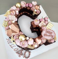 a cake shaped like the number six with pink and gold decorations