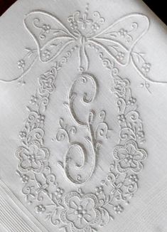 the monogrammed napkins are decorated with white thread and embellishments