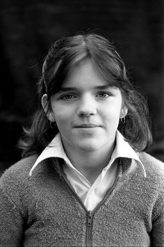 an old black and white photo of a young woman with long hair wearing a sweater