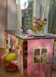 a room with a table and chairs in it, next to a potted plant