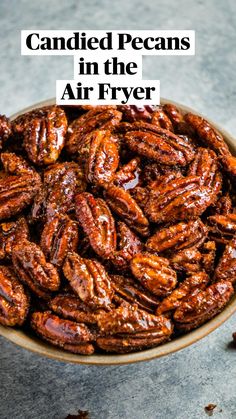 a bowl full of pecans sitting on top of a gray countertop next to some dried nuts