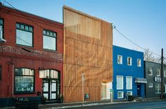 a row of buildings with wooden slats on the front and side of each building