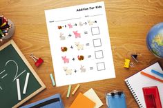 an addition for kids worksheet on a desk with school supplies and pencils