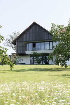 a large house sitting on top of a lush green field