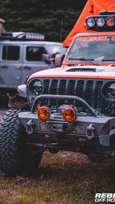 an orange jeep is parked in the grass